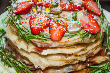 A variety of original pancakes with fresh strawberries and rosemary in the contest during the celebration Russian Shrovetide (pancake week) at school