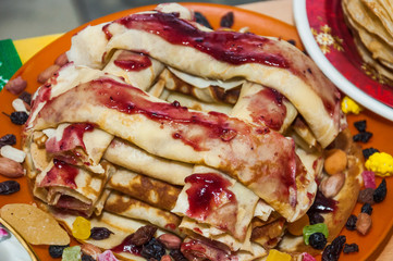 A variety of original pancakes with curd filling and anointed by the jam in the contest during the celebration Russian Shrovetide (pancake week) 