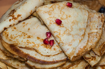 A variety of original pancakes folded triangles with pomegranate seeds in the contest during the celebration Russian Shrovetide (pancake week) 