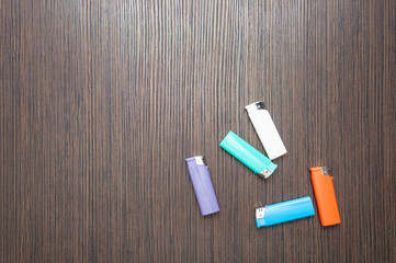 Multicolored lighters on a dark wooden table