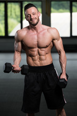 Bodybuilder Exercising Biceps With Dumbbells