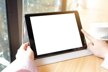 Digital tablet computer with isolated screen in female hands over cafe background - table, cup of coffee shop