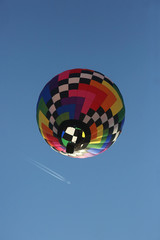 hot air balloon with jet airplane flying above