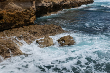 Ocean water surrounding rocks on the coast.
