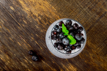 Healthy breakfast with chia seeds vanilla pudding and berries on wooden rustic background, vegetarian food