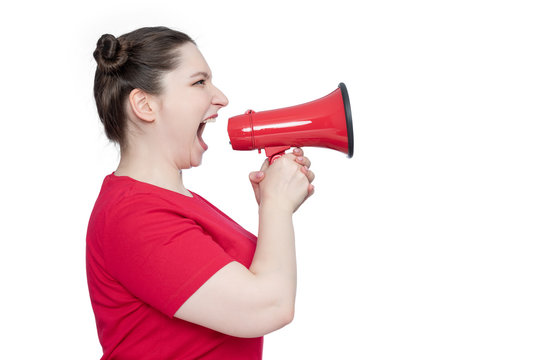 Young woman in red t-shirt screaming into a megaphone, side view, isolated on white background