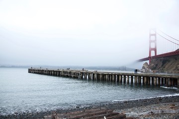 Golden gate bridge on foggy day with pier below in the foreground 