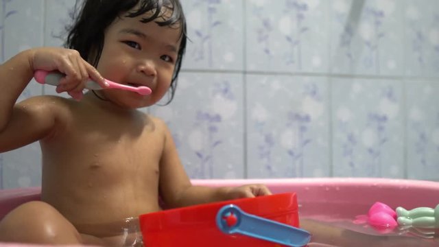 Little asian girl take a bath in the bathroom,Thailand people