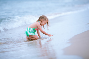 Little cute happy girl swims in the sea, Spain