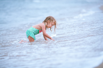 Little cute happy girl swims in the sea, Spain