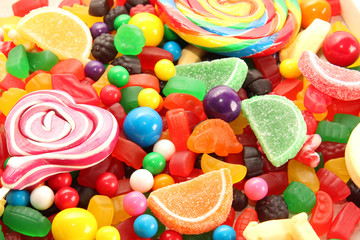 Fototapeta na wymiar Assorted variety of sweet sugar candies includes lollipops, gummy bears, gum balls and sugar fruit slices. Kids birthday party concept. Flat lay. 