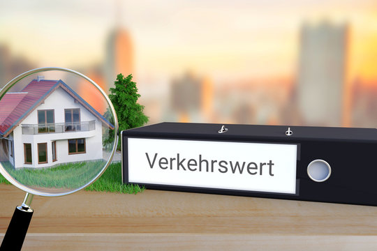 Marktwert einer Immobilie. Ordner beschriftet mit dem Begriff Verkehrswert liegt neben einem Haus-Modell mit Lupe auf einem Schreibtisch. Skyline einer Stadt im Hintergrund.