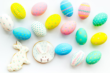 Colorful Easter eggs and gingerbread background on white top view