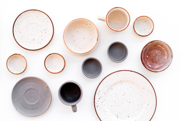Kitchen concept. Crockery kit. Empty ceramic plates and mugs on white background top view