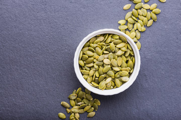 Peeled pumpkin seeds in a bowl, top view