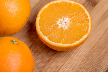 Orange fruit cut on halves on a wooden surface