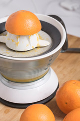 Orange fruits on a domestic juice machine