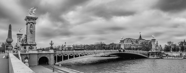 Moody cityscape panorama with Pont Alexandre III bridge and Seine river in Paris, France in black...