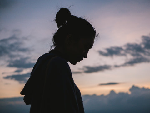 Silhouette Of Asian Woman At Sunset