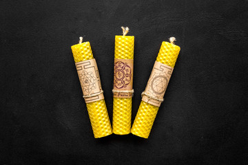 Buddhism. Candles with Yantras and mantras in sanskrit on black background top view copy space