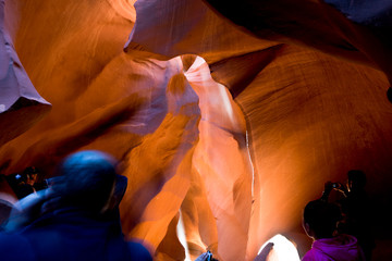 Tourists take pictures of the unique natural diverse sand labyrinths of the lower Antelope Canyon