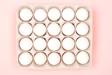 Eggs in egg box on pink background