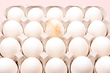 Eggs in egg box on pink background