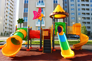 Colorful playground in the yard with plastic slides and other objects