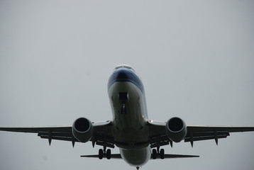 Airplane on descending, wheels out, low hight, on the way to the runway strip on the rainy day
