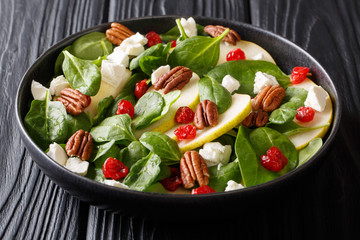 Fitness salad of pears, baby spinach, pecans, feta cheese and cherries closeup. Healthy breakfast. horizontal