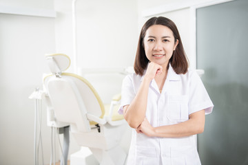 Fototapeta premium Portrait of female dentist standing in dental office