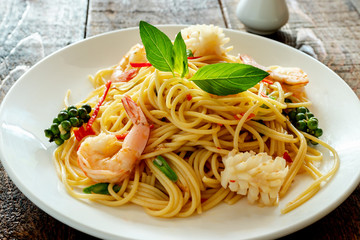 spicy spaghetti with seafood on plate.