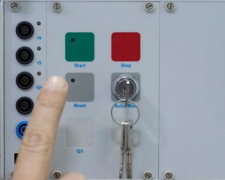 Male Hand Pushing Stop and Reset Buttons of Control Panel for Electrical Equipment in a Smart Factory. Industry 4.0 Concept Smart Factory Automation Line Control.