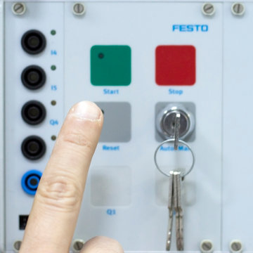 Male Hand Pushing Stop and Reset Buttons of Control Panel for Electrical Equipment in a Smart Factory. Industry 4.0 Concept Smart Factory Automation Line Control.