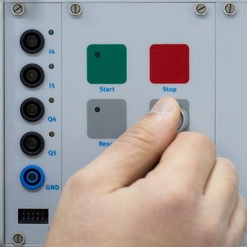 Male Hand turning start switch key of Control Panel for Electrical Equipment in a Smart Factory. Industry 4.0 Concept Smart Factory Automation Line Control.