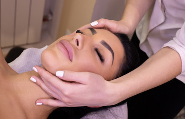 woman enjoying in her relaxing head massage at the spa