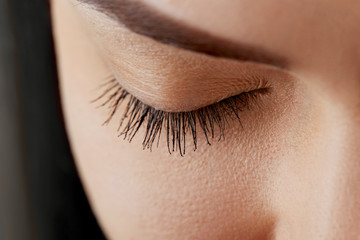 Beautiful Woman with long lashes in a beauty salon. Eyelash extension procedure. Cosmetics and makeup.