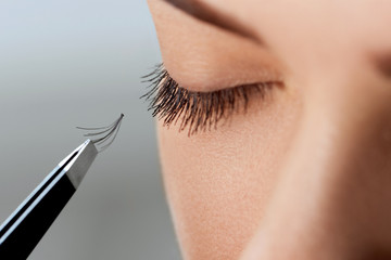 Eyelash Extension Procedure. Woman Eye with Long Eyelashes. Lashes, close up, macro, selective focus.Cosmetics and makeup