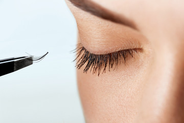 Beautiful Woman with long eyelashes in a beauty salon. Eyelash extension procedure. Lashes close up. Cosmetics and makeup. Close Up macro shot of fashion eyes visage.Cosmetics and makeup.