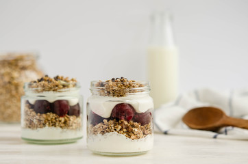 Homemade granola with cherry, yogurt in a glass jar