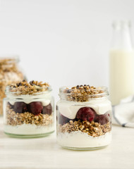 Homemade granola with cherry, yogurt in a glass jar