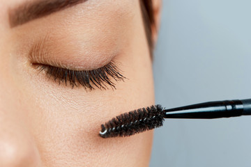 Beautiful Woman with long eyelashes in a beauty salon. Eyelash extension procedure. Lashes close up.Cosmetics and makeup.