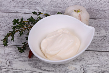 Mayonnaise sauce in the white bowl served thyme and garlic