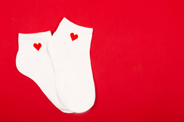 Pair of white socks on red background