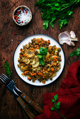 Green lentils with mushrooms and vegetables, vintage wooden kitchen table background, place for text. Vegan or vegetarian meal, clean food concept. Top view