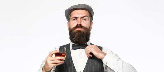 Brutal bearded man with glass of whiskey, brandy, cognac. Attractive man with a cognac. Old hipster style. Whiskey, brandy, cognac drink.