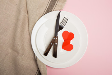 Festive table setting for Valentine's Day with fork, knife,  hearts on a red background. Top view. - Image.