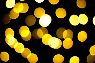 Beautiful yellow and white bokeh on a black background. Can be used as a background or wallpaper.