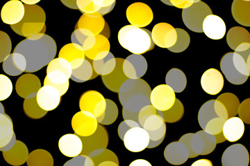 Beautiful yellow and white bokeh on a black background. Can be used as a background or wallpaper.