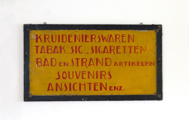 Sign saying 'groceries, tabaco, cigarettes, bath, beach, souvenirs and postcards' in dutch